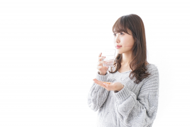 サプリメントを飲む女性